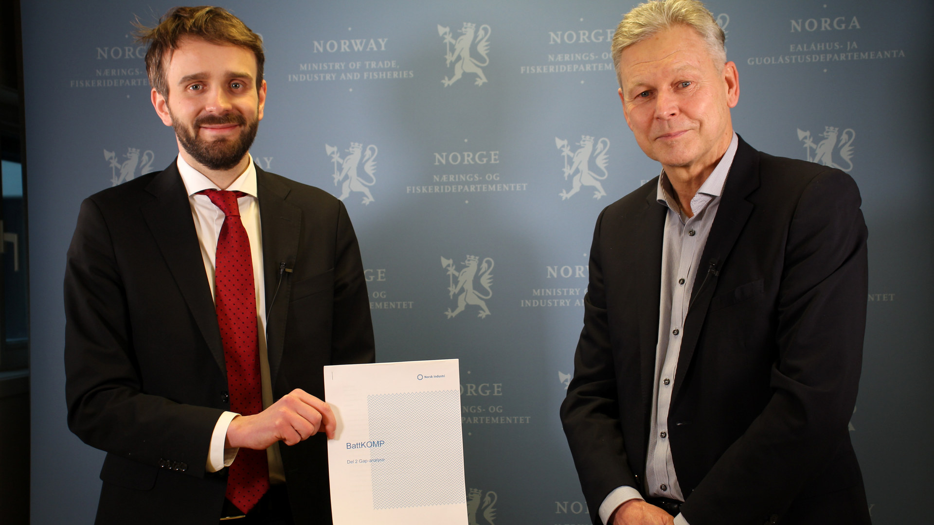 Næringsminister Jan Christian Vestre mottar rapporten for fase 2 av BattKOMP-prosjektet. Rapporten ble overlevert av Petter Arnesen fra Norsk Industri. Foto: Næringsdepartementet