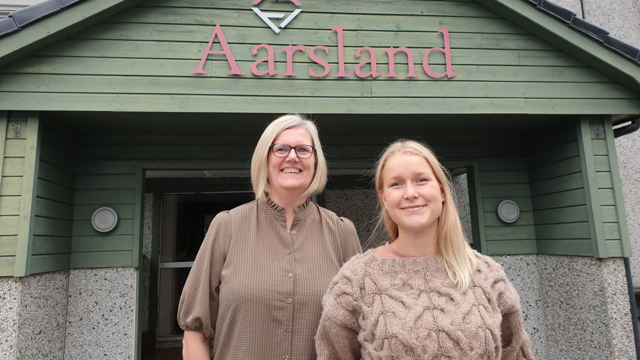 To damer forran inngangsparti til Aarsland Møbelfabrikk