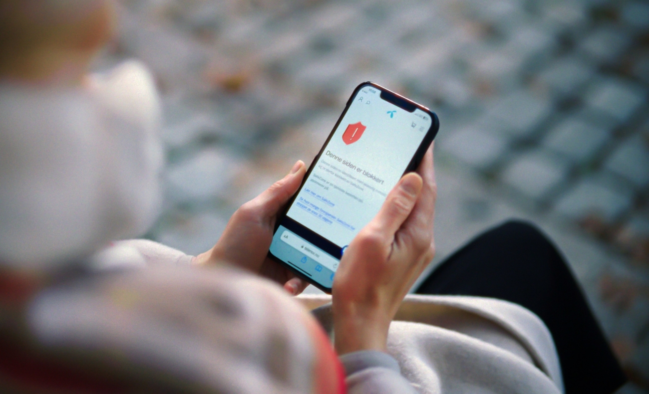 Person som holder en mobiltelefon i hånden
