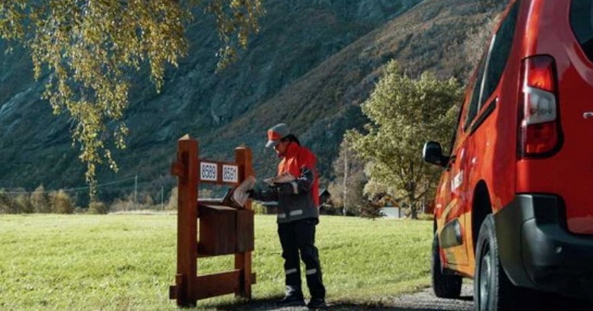 Postbil og postombud som leverer post i postkasse