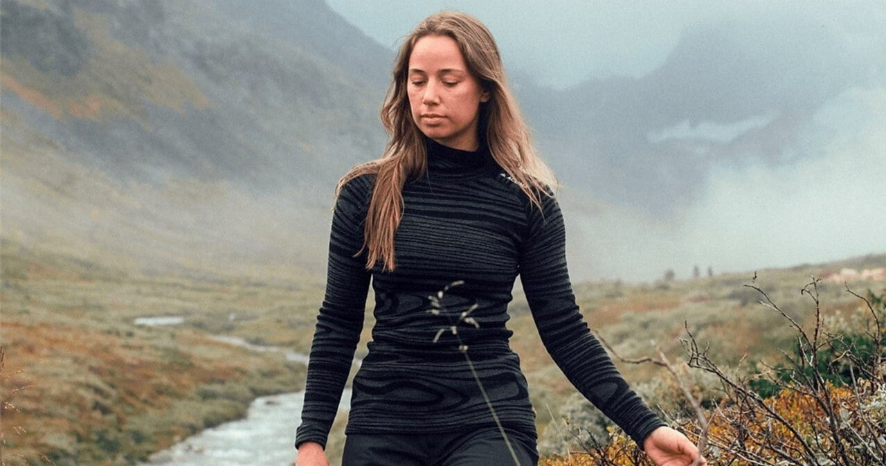 Dame som går på tur i fjellet med sportsklær.