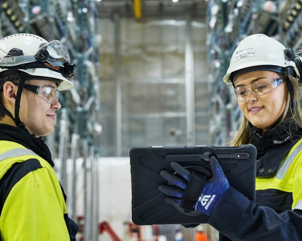 To arbeidere i et fabrikkmiljø