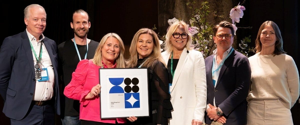 En blid gjeng som mottar designpris.