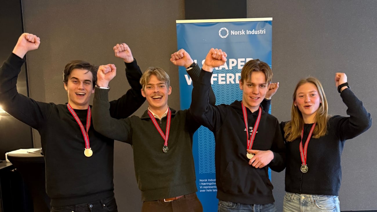 Fire personer med medalje på en scene