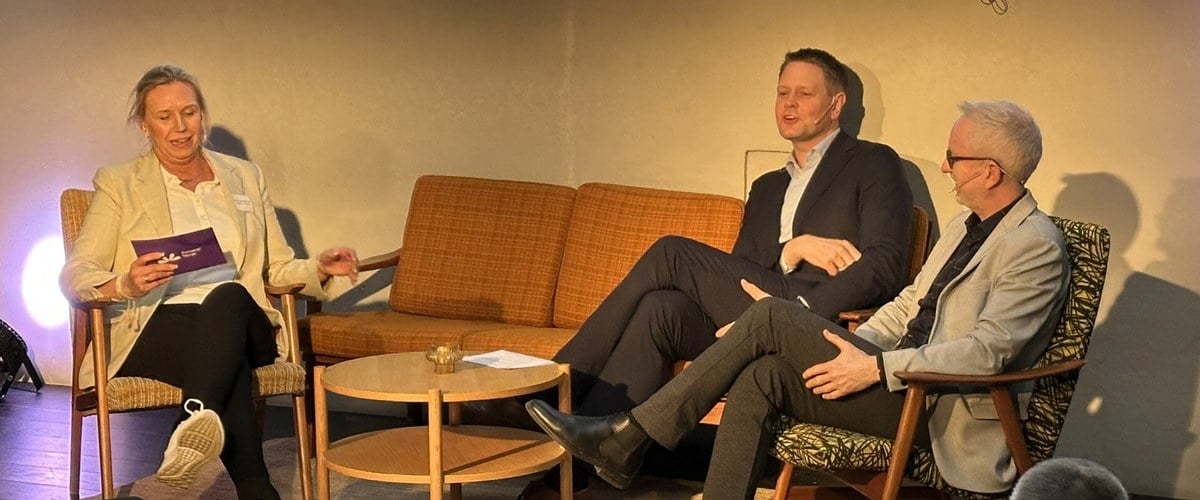 Tre folk i diskusjon på et seminar