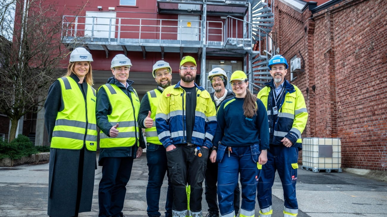 Blide mennesker foran en industribedrift