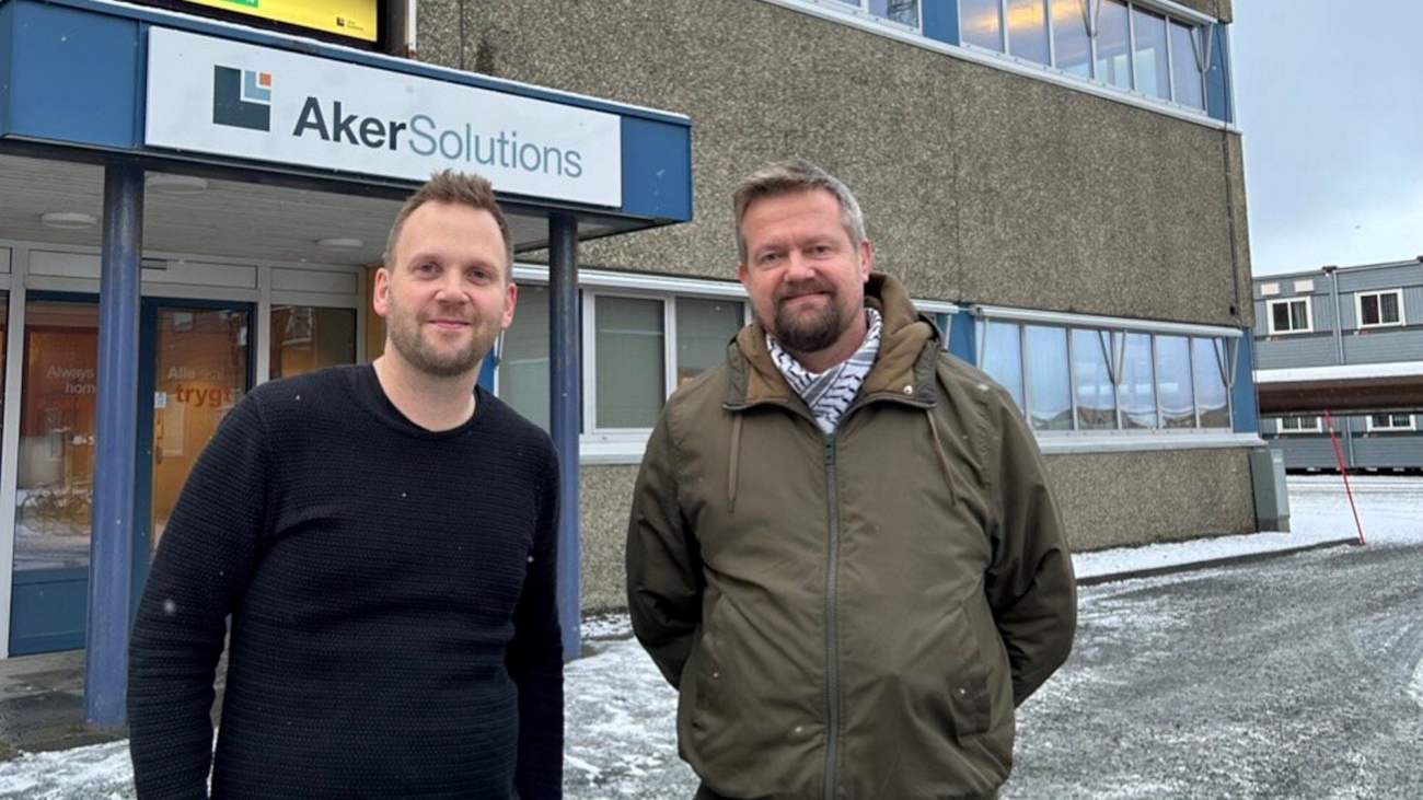 To menn foran et fabrikkbygg