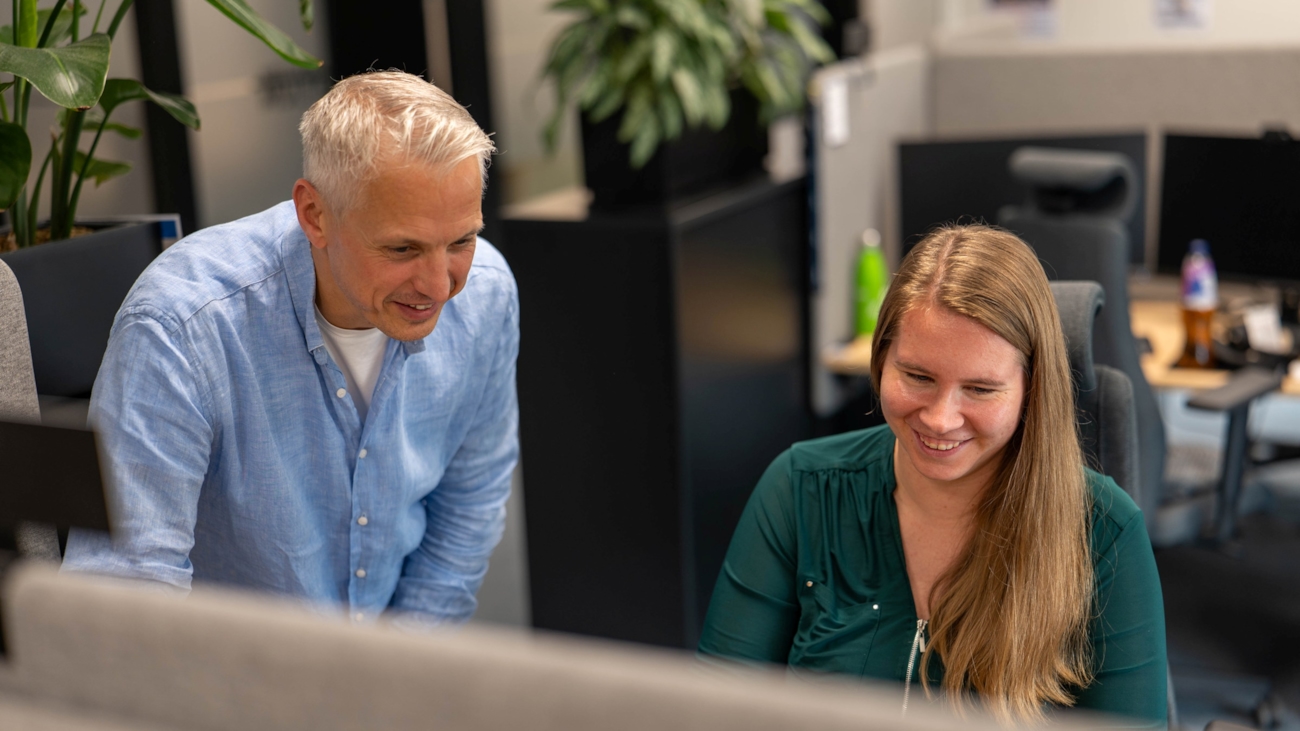 To personer bøyd over en pc-skjerm