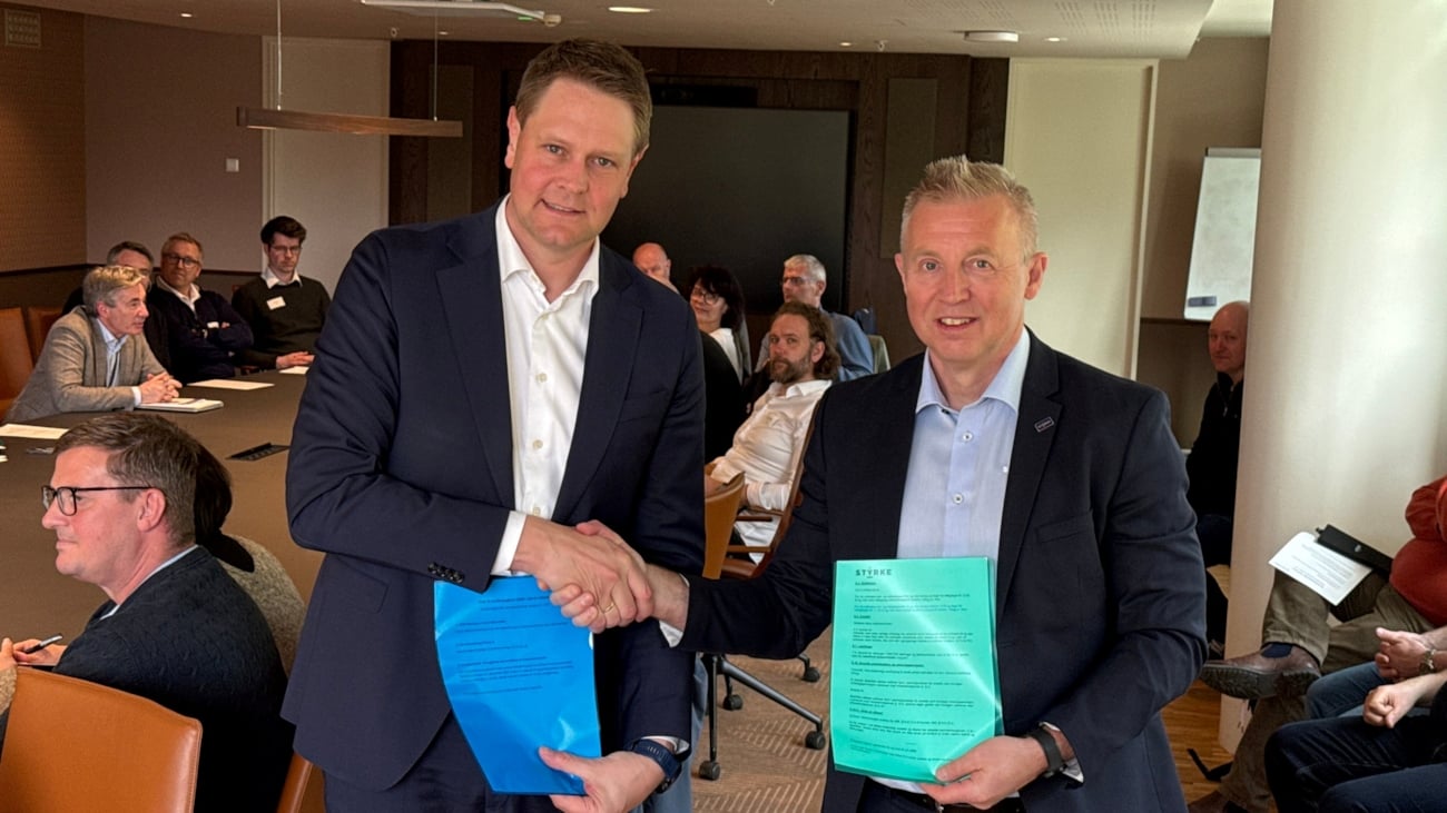 To personer som overrekker dokumenter til hverandre