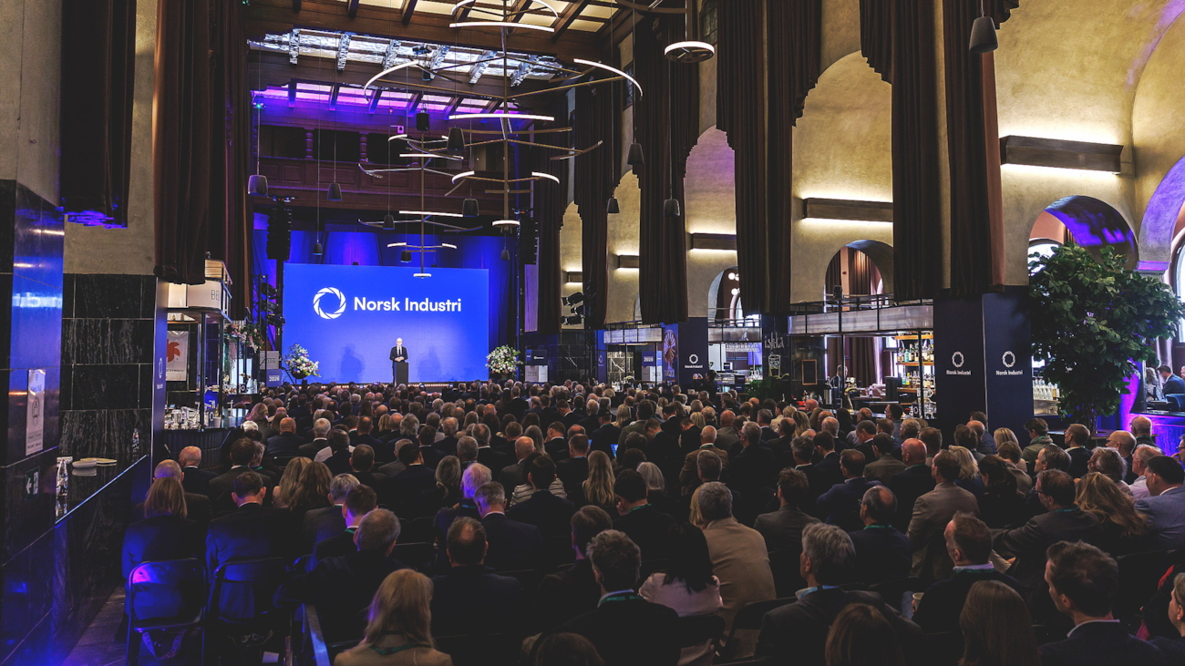 Person på scene i en fullsatt sal.
