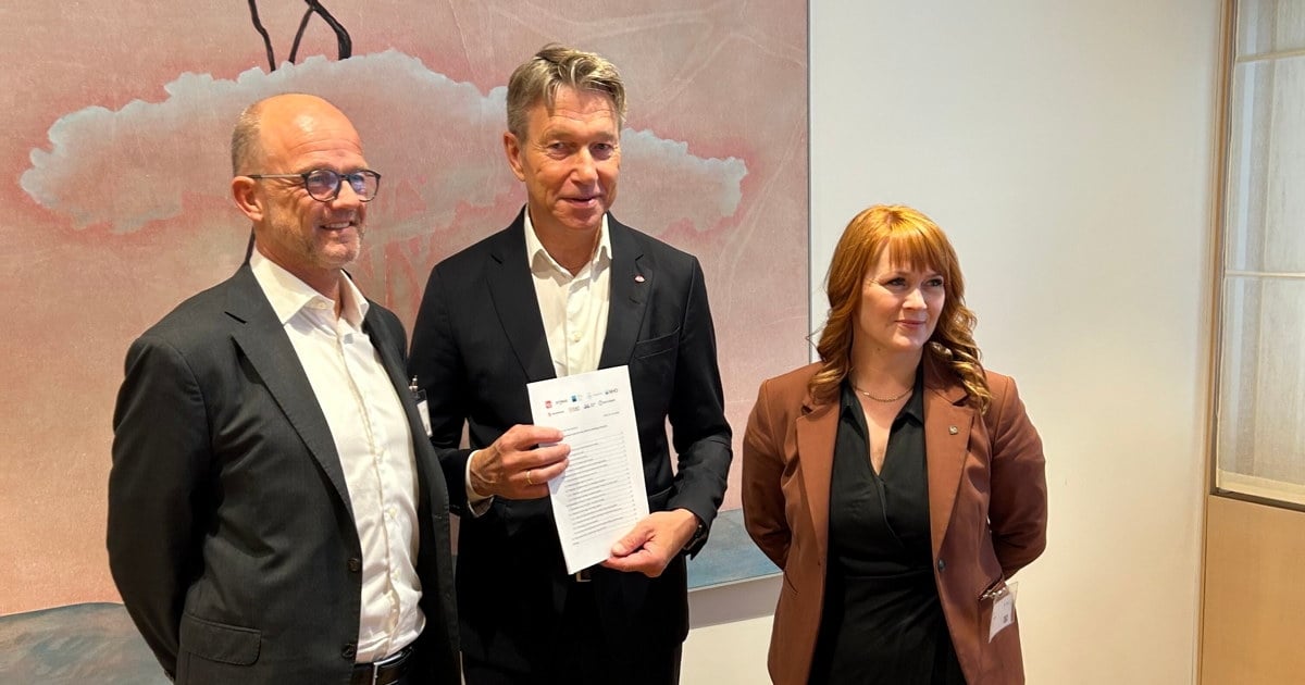 Tre personer som holder i et notat